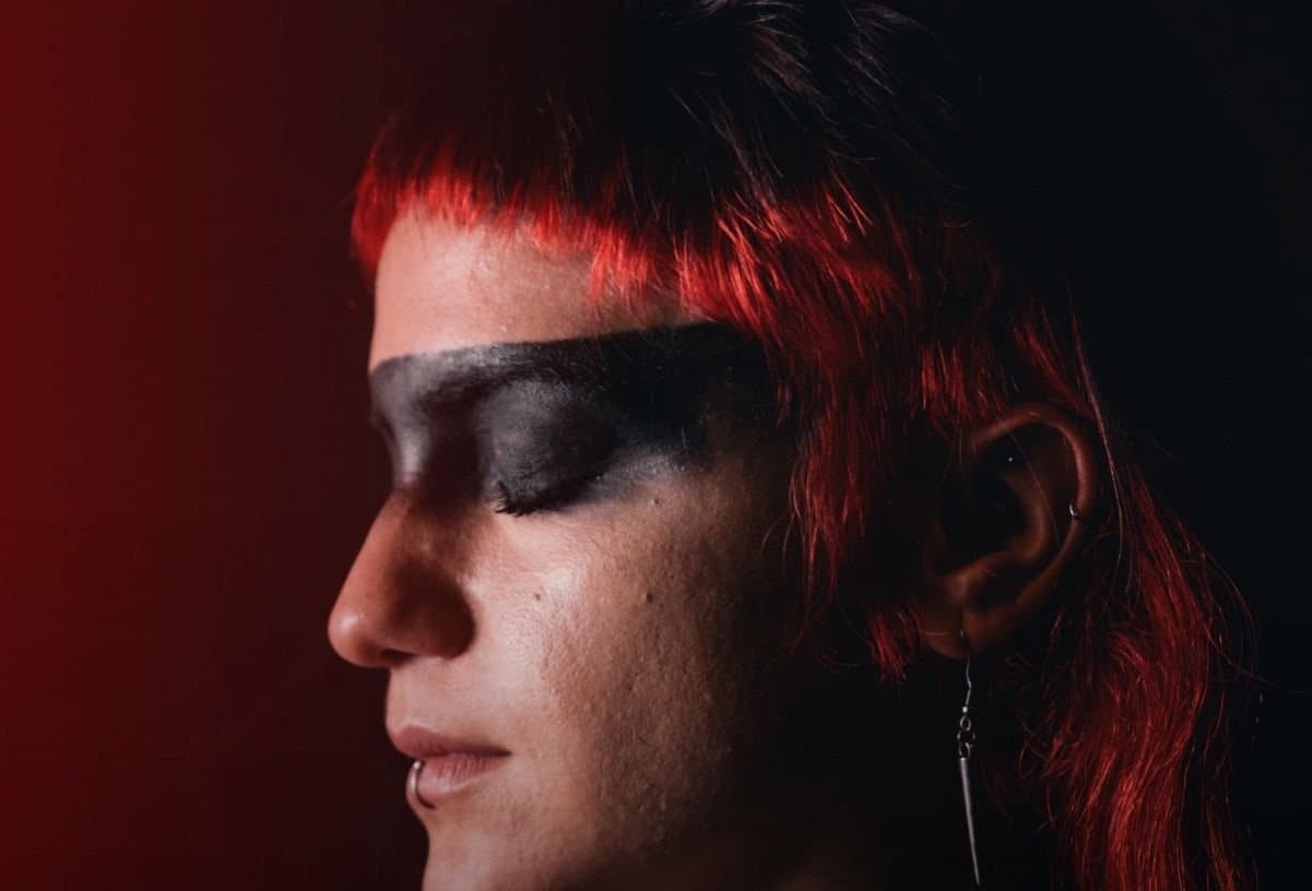Kuiã in profile, with a red fringe and a band of black make-up across the eyes