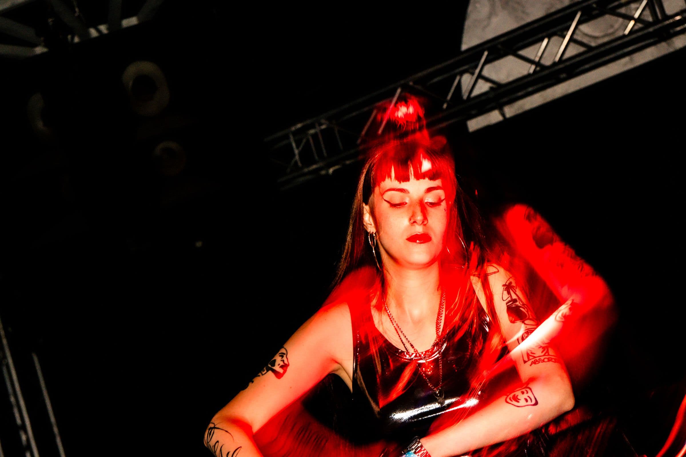 HER DJ behind the decks, bathed in red light